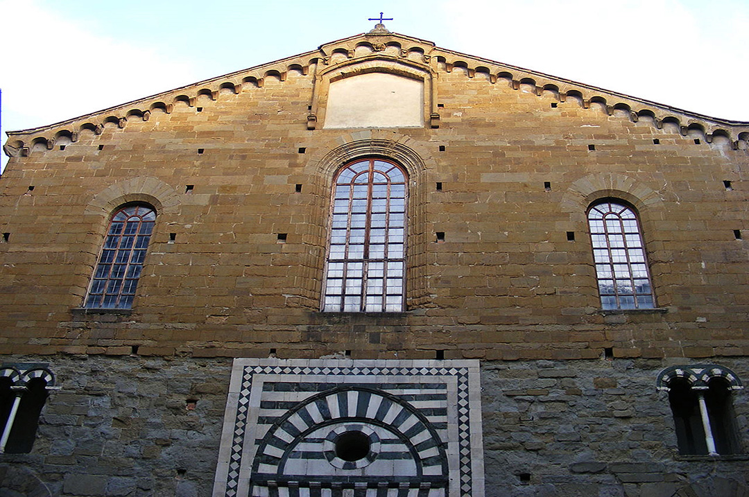 Facciata della storica Chiesa di San Lorenzo a Firenze, con dettagli architettonici e finestre gotiche.